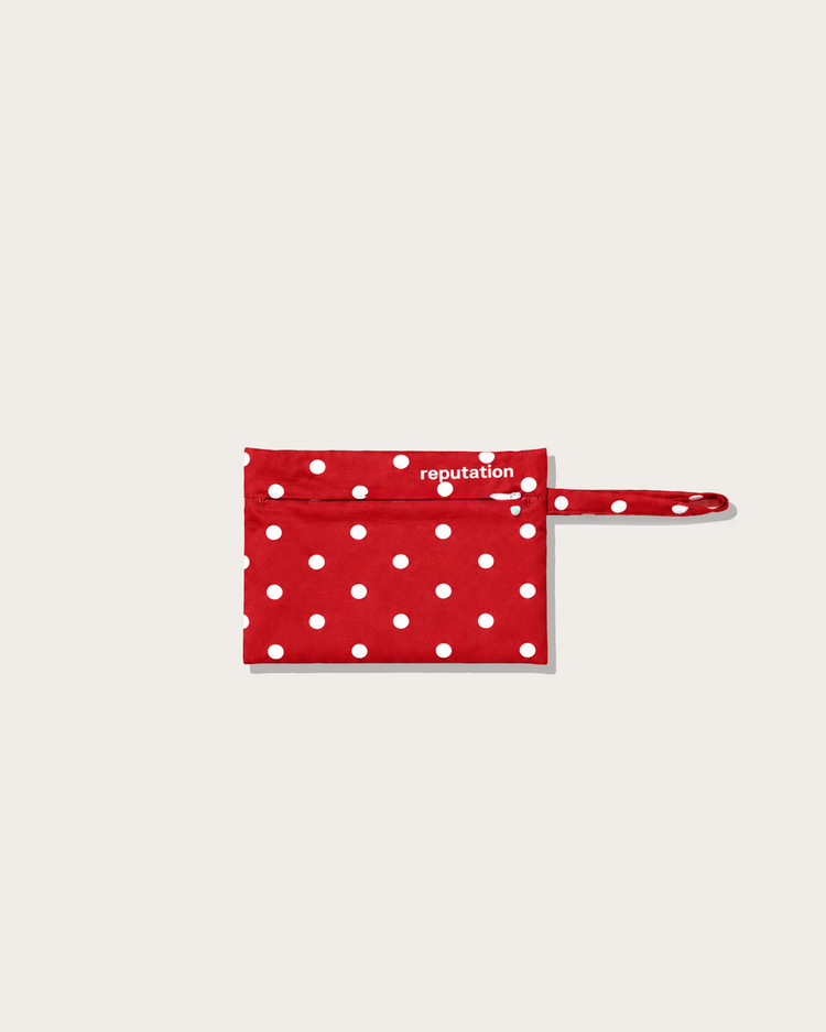 Reputation Polka Dots swimwear packaging pouch in red, flat lay